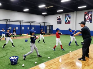 Hitclub baseball training session with young players hitting under bright lights in a modern facility